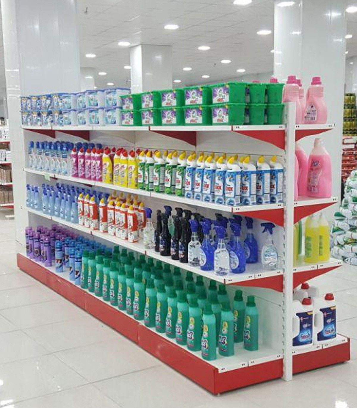 قفسه فلزی وسط فروشگاه با چیدمان متنوع محصولات شوینده و بهداشتی سامان انبار شرق طوس مشبک.